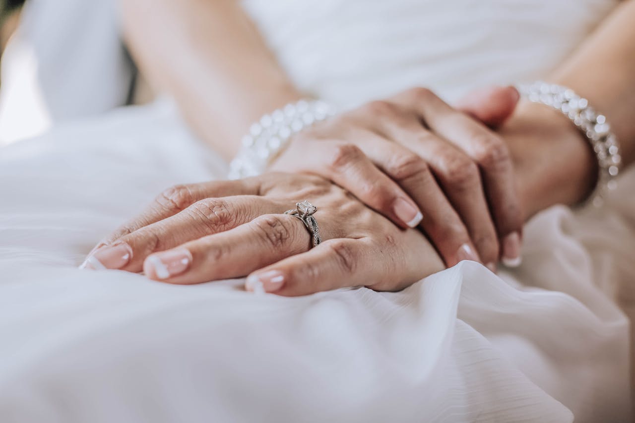 our-services-03 Close-up image of a bride's hands adorned with a wedding ring and jewelry, showcasing elegance.